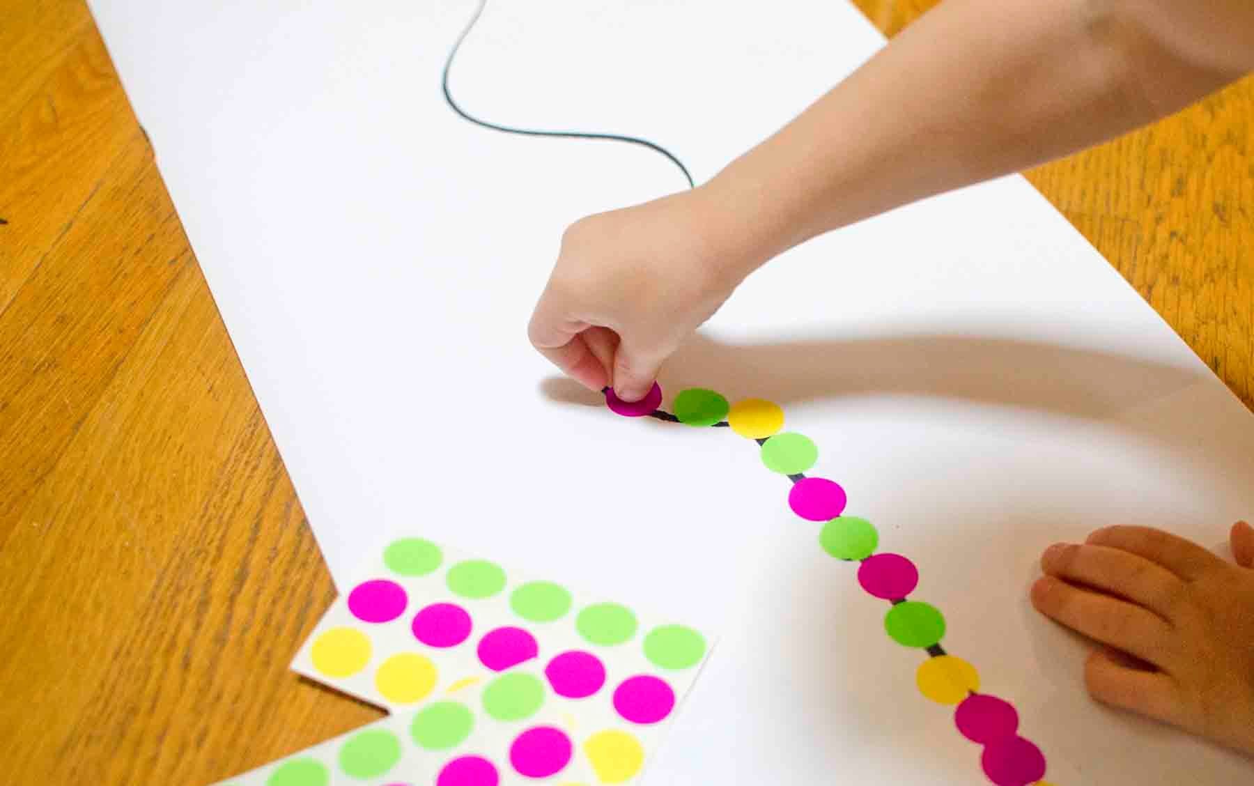 Kids playing and learning with stickers for fun and fine motor development  - Laughing Kids Learn